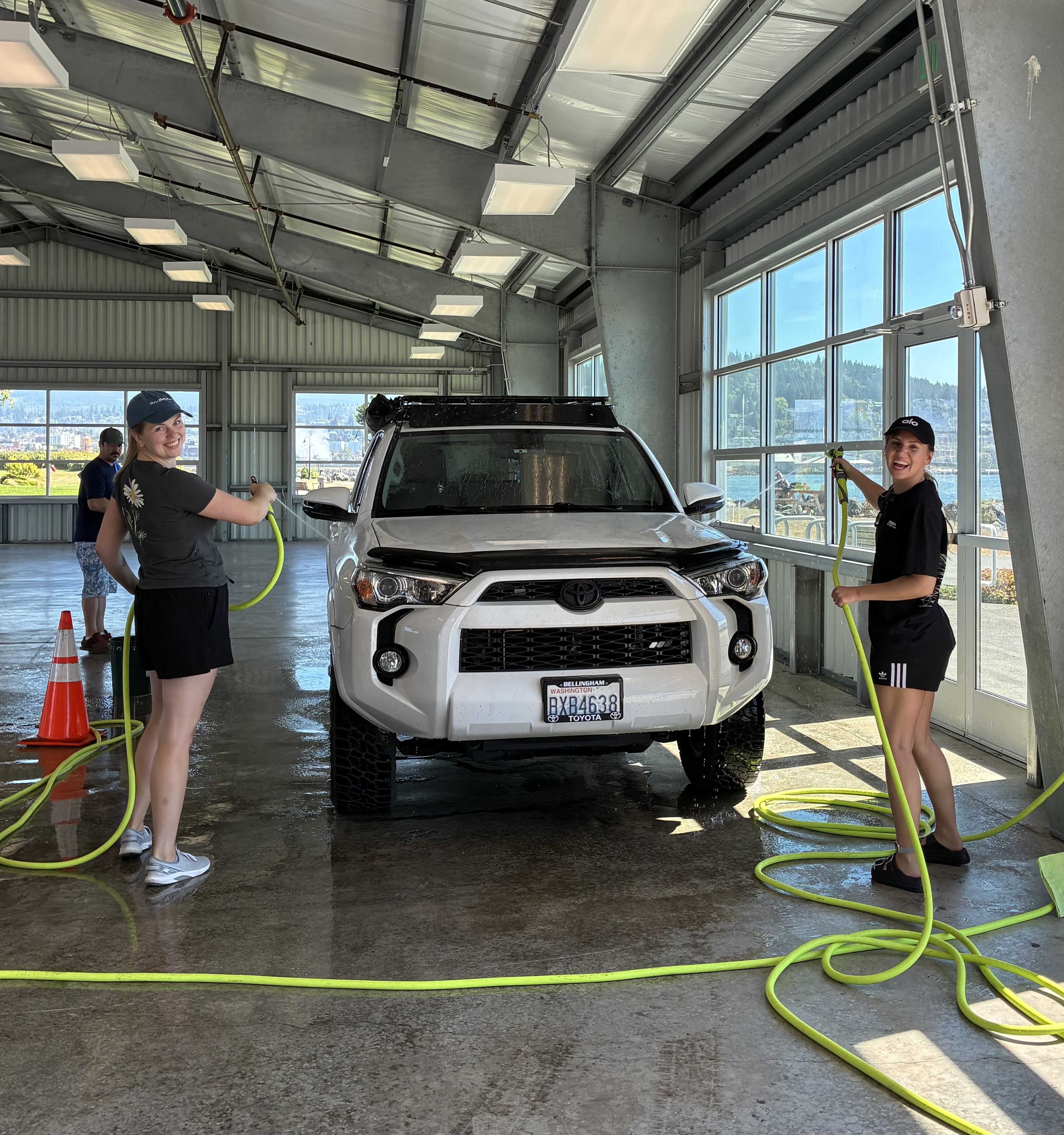 Two Port of Bellingham employees smile while washing a car